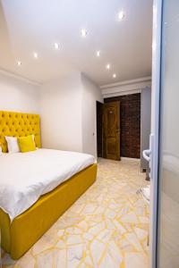 a bedroom with a large bed and a yellow headboard at Pensiunea Ewo in Iaşi