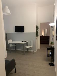 een woonkamer met een tafel en een tv aan de muur bij Mc - Piazza Mancini in Rome
