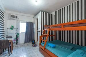 a bedroom with a bunk bed and a dining room at Pier La Casa Homestay Building in Surigao