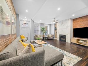 a living room with a couch and a tv at Stylish 4 Bedroom Loft Home, North Shore, City Skyline View Close to NHL, NFL in Pittsburgh