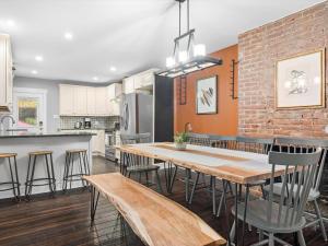 a kitchen and dining room with a wooden table and chairs at Stylish 4 Bedroom Loft Home, North Shore, City Skyline View Close to NHL, NFL in Pittsburgh