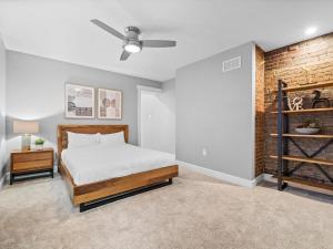 ein Schlafzimmer mit einem Bett und einer Ziegelwand in der Unterkunft Stylish 4 Bedroom Loft Home, North Shore, City Skyline View Close to NHL, NFL in Pittsburgh