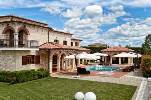 widok na dom z basenem i parasolami w obiekcie Villa Carolus-Luxurious Istrian Villa w mieście Barat