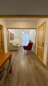 a living room with a red chair and a couch at Primero el Wiro in Puerto +8 photos