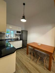 a kitchen with a wooden table and a wooden floor at Primero el Wiro in Puerto