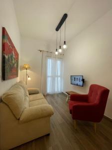 - un salon avec un canapé et un fauteuil rouge dans l'établissement Primero el Wiro, à Puerto