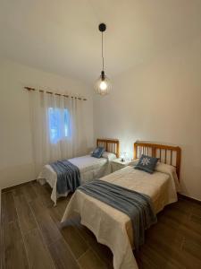 a bedroom with two beds and a light fixture at Primero el Wiro in Puerto
