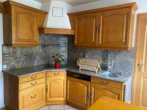 uma cozinha com armários de madeira e um lavatório em Appartement 3 lys em Saint-Louis