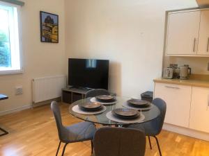 a living room with a table and chairs and a tv at Private Parking 2 Bed 2 bath in Edinburgh