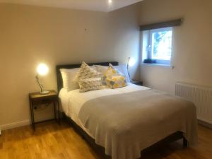 um quarto com uma cama com almofadas e uma janela em Private Parking 2 Bed 2 bath em Edimburgo