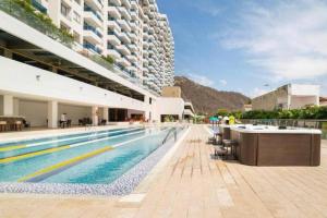 un gran edificio con una piscina al lado de un edificio en CONDOMINIO EN SANTA MARTA CON SALIDA AL MAR, en Santa Marta