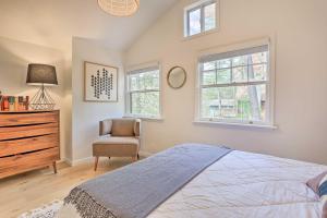 a bedroom with a bed and a dresser and windows at Shohola Waterfront Cabin with Deck, Grill and Fire Pit in Shohola