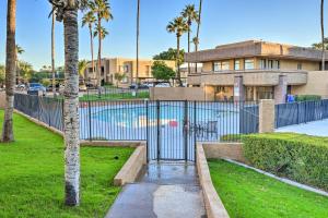 a gate in front of a building with palm trees at Chic Phoenix Condo Pool Access, Close to Hiking in Phoenix