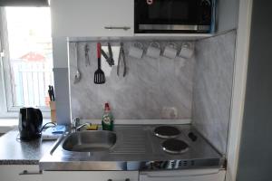 a kitchen with a sink and a stove and a microwave at Harbourside Hotel in Irvine