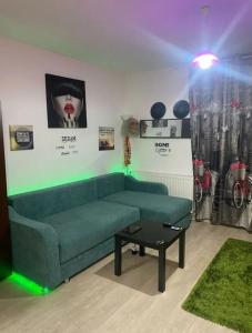 - un salon avec un canapé vert et une table dans l'établissement ModernStudio, à Bragadiru
