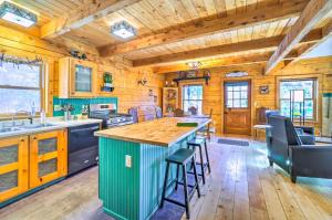 una cucina con pareti in legno e soffitto in legno di Secluded Black Hawk Log Cabin with Fire Pit! a Black Hawk