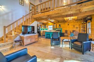 uma sala de estar com uma escada e uma mesa e cadeiras em Secluded Black Hawk Log Cabin with Fire Pit! em Black Hawk