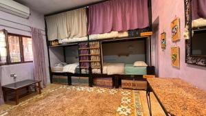 a room with two bunk beds and a mirror at Carob Hostel in Amman