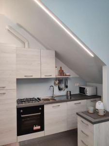 a kitchen with white cabinets and a black stove top oven at Soggiorno a 5 stelle, tra mare, cultura e natura in Cattolica