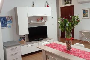 un salon avec une table et un vase de fleurs dans l'établissement Soggiorno a 5 stelle, tra mare, cultura e natura, à Cattolica