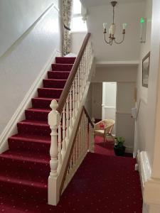 a red carpeted staircase with a red carpeted stair case at Glendale Guest House in Keswick