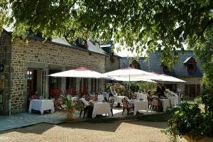 a group of people sitting at tables with umbrellas at Logis La Marjolaine in Moulay