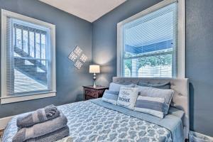 a bedroom with a bed with blue walls and windows at Charming Jacksonville Home about 2 Mi to Downtown! in Jacksonville