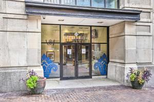 a store front with glass doors and two potted plants at Historical Apt in Dtwn Omaha - Pets Welcome! in Omaha