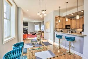 a kitchen and living room with a glass table and blue chairs at Historical Apt in Dtwn Omaha - Pets Welcome! in Omaha