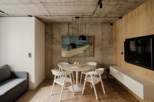 a dining room with a table and chairs and a tv at Apartamenty z widokiem na morze i dziedziniec BalticON Morska 6 in Kołobrzeg
