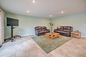 a living room with two couches and a flat screen tv at Family Home on Crystal Lake with Private Beach! in Hart