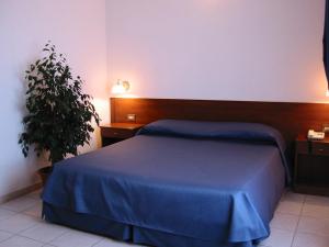 a bedroom with a blue bed and a plant at Hotel Su Giudeu in Chia