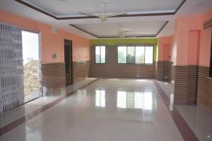 una grande stanza vuota con pareti arancioni e un soffitto di Airport Lodge a Siliguri
