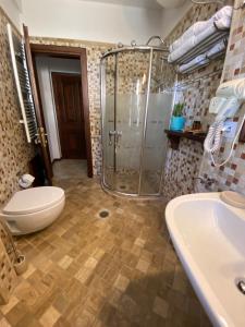 a bathroom with a shower and a toilet and a sink at Boutique Hotel Muzaka (Historic Center) in Berat