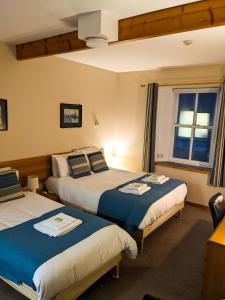 Habitación de hotel con 2 camas y ventana en Ferry Inn, en Stromness
