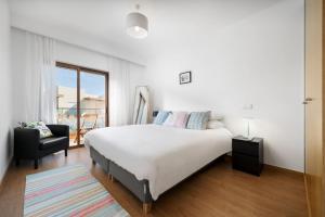 a bedroom with a bed and a chair and a window at Terraços do Rio by CORAL in Portimão +27 photos