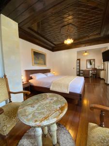 a bedroom with a bed and a table in it at Boutique Hotel Muzaka (Historic Center) in Berat