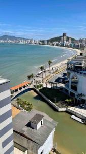 a view of a beach and the ocean from a building at Apartamento Frente Mar com vista praia em Itapema in Itapema