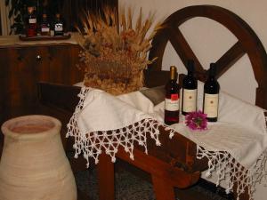 a table with bottles of wine and a vase at Hotel Su Giudeu in Chia