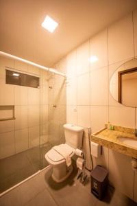 uma casa de banho com um WC, um chuveiro e um lavatório. em Barra De Maragogi Pousada em Maragogi