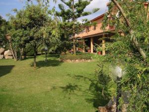 a house with a yard with grass and trees at Hotel Su Giudeu in Chia