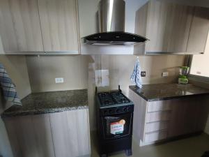 a kitchen with a stove and a counter top at Edificio Atlantis Tower, Confortable y Agradable in Santa Cruz de la Sierra