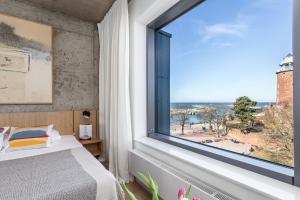 a bedroom with a large window with a view of the ocean at Apartamenty z widokiem na morze i dziedziniec, parking BalticON Morska 6 in Kołobrzeg