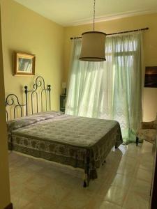a bedroom with a bed and a large window at Lo studio di Gabriella in Bolsena