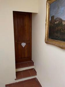 a hallway with a wooden door with a heart on it at Lo studio di Gabriella in Bolsena