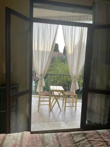 - une chambre avec vue sur un balcon doté d'un lit et de chaises dans l'établissement Lo studio di Gabriella, à Bolsena
