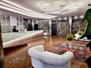 モンテッキオ・マッジョーレにあるHotel & Residence Castelliの白いソファとテーブルが備わるロビー