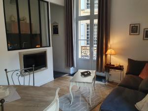 a living room with a couch and a tv at L appart d en face in Sarlat-la-Canéda