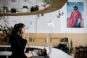 una mujer hablando por un celular en una oficina en Met Hotel en La Paz