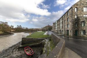 a red boat parked next to a building next to a river at The Helm Apartments B&B in Westport